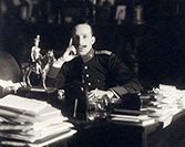 Retrato del rey Alfonso XIII sentado ante su mesa de despacho con el uniforme del regimiento Inmemorial del rey